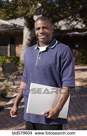 Black man carrying laptop View Large Photo Image Picture - Black man carrying laptop. Fotosearch
