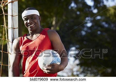 Stock Photo - Black man holding soccer ball. Fotosearch