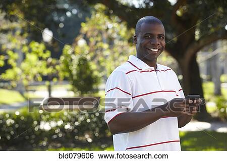 Black man text messaging on cell phone View Large Photo Image Stock Photograph - Black man text messaging on cell phone. Fotosearch