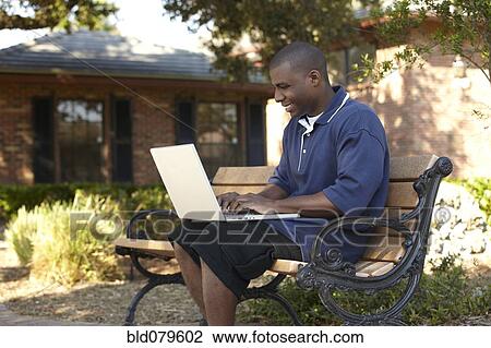 Stock Image - Black man typing on laptop. Fotosearch