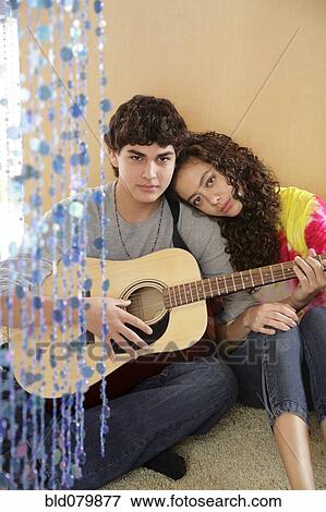 Stock Photo - Boyfriend playing guitar for girlfriend. Fotosearch
