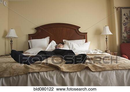 Chinese businessman sleeping in hotel bed View Large Photo Image Stock Image - Chinese businessman sleeping in hotel bed. Fotosearch