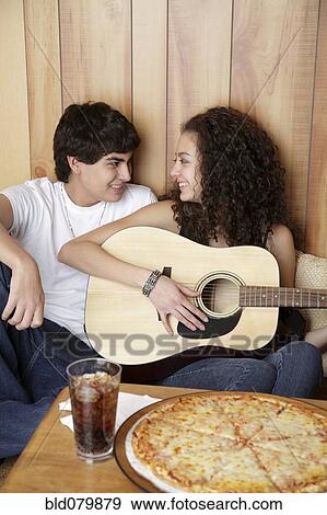 Stock Photo - Girlfriend playing guitar for boyfriend. Fotosearch