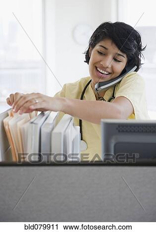 Hispanic nurse talking on telephone View Large Photo Image Stock Image - Hispanic nurse talking on telephone. Fotosearch
