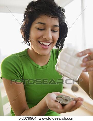 Picture - Hispanic woman emptying coin purse. Fotosearch