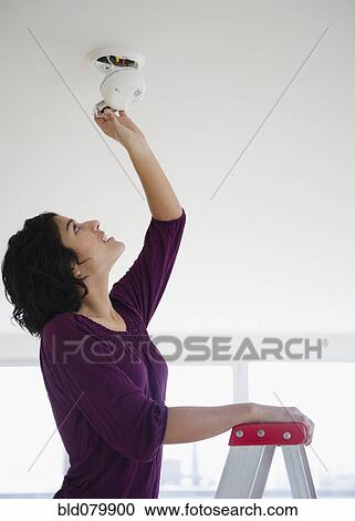 Hispanic woman fixing fire alarm View Large Photo Image Stock Image - Hispanic woman fixing fire alarm. Fotosearch