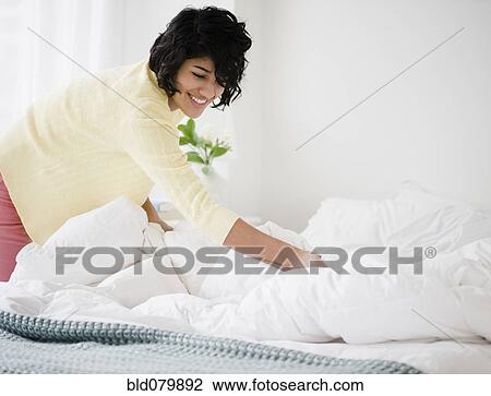 Hispanic woman making bed View Large Photo Image Stock Image - Hispanic woman making bed. Fotosearch