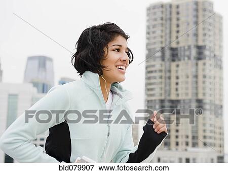 Stock Photo - Hispanic woman running in city. Fotosearch