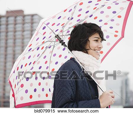 Hispanic woman walking in city with umbrella View Large Photo Image Stock Photography - Hispanic woman walking in city with umbrella. Fotosearch