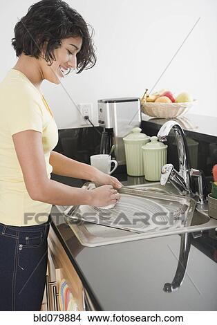 Hispanic woman washing pan in kitchen View Large Photo Image Picture - Hispanic woman washing pan in kitchen. Fotosearch