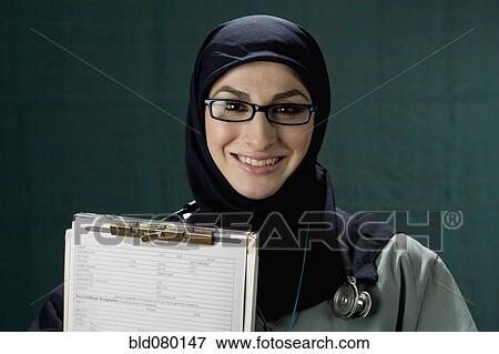 Middle Eastern doctor holding medical chart View Large Photo Image Stock Photo - Middle Eastern doctor holding medical chart. Fotosearch