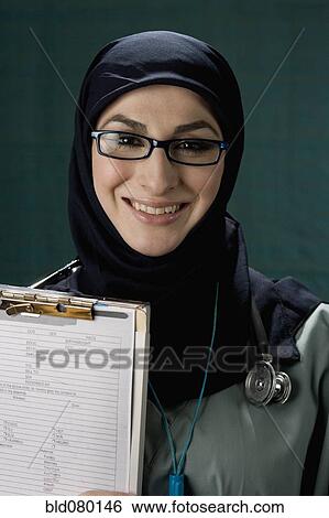 Middle Eastern doctor holding medical chart View Large Photo Image Stock Photograph - Middle Eastern doctor holding medical chart. Fotosearch