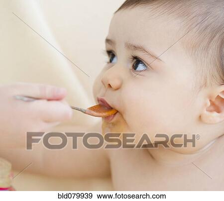 Stock Photo - Mixed race baby boy eating. Fotosearch