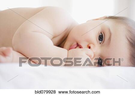 Stock Photo - Mixed race baby boy sucking thumb. Fotosearch