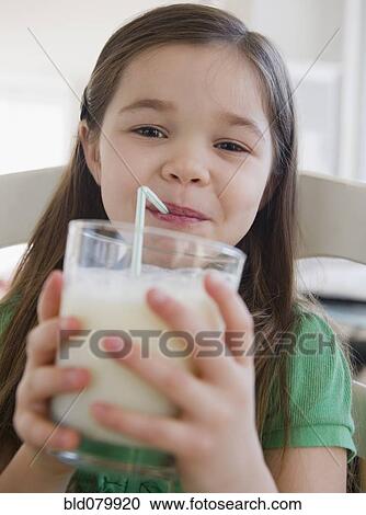 Stock Image - Mixed race girl drinking milk. Fotosearch