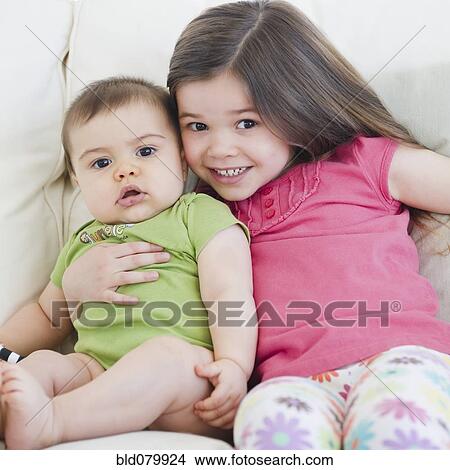 Picture - Mixed race girl hugging brother. Fotosearch