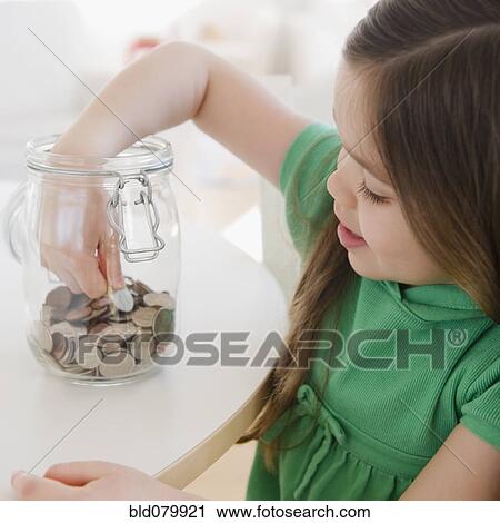 Mixed race girl taking coin out of jar View Large Photo Image Stock Image - Mixed race girl taking coin out of jar. Fotosearch