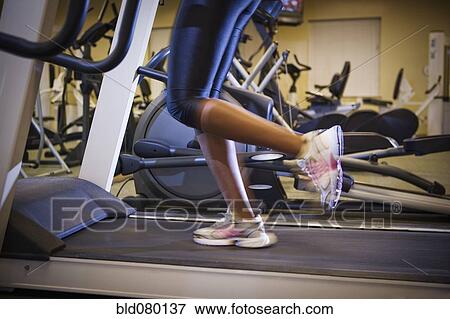 Mixed race woman running on treadmill in gym View Large Photo Image Stock Photo - Mixed race woman running on treadmill in gym. Fotosearch