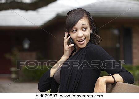 Stock Photo - Mixed race woman talking on cell phone. Fotosearch
