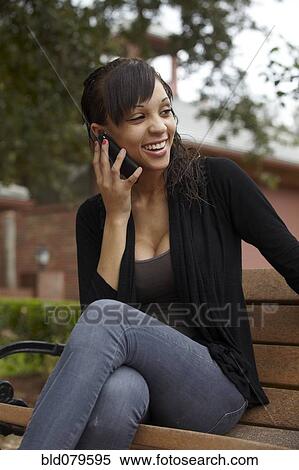 Stock Photography - Mixed race woman talking on cell phone. Fotosearch