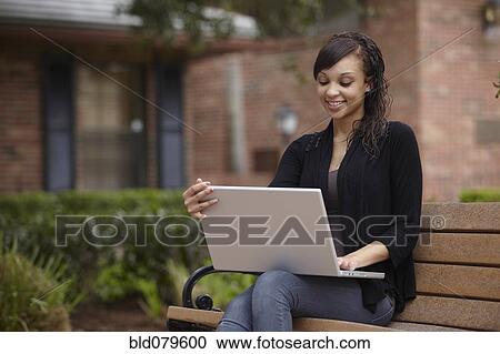 Stock Image - Mixed race woman typing on laptop. Fotosearch