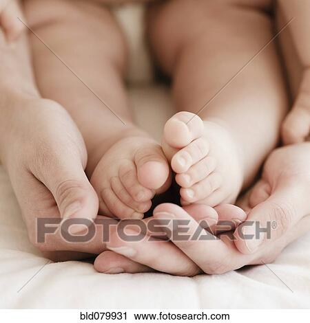 Mother holding mixed race baby boy's feet View Large Photo Image Stock Image - Mother holding mixed race baby boy's feet. Fotosearch