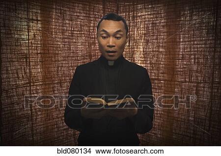 Pacific Islander priest reading bible View Large Photo Image Picture - Pacific Islander priest reading bible. Fotosearch