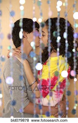 Stock Photo - Young couple kissing behind screen. Fotosearch