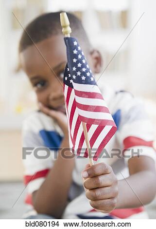 Picture - Black boy holding small American flag. Fotosearch