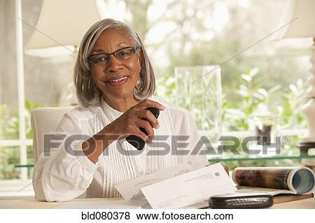 Black woman holding paper and cell phone View Large Photo Image Stock Photo - Black woman holding paper and cell phone. Fotosearch