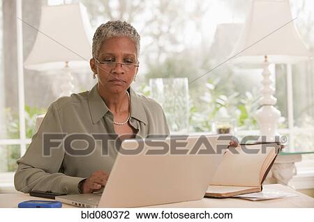 Black woman working on laptop View Large Photo Image Stock Image - Black woman working on laptop. Fotosearch