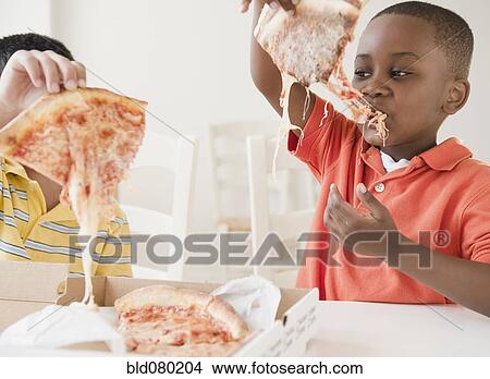 Picture - Boys eating pizza together. Fotosearch