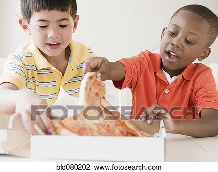 Boys eating pizza together View Large Photo Image Stock Image - Boys eating pizza together. Fotosearch