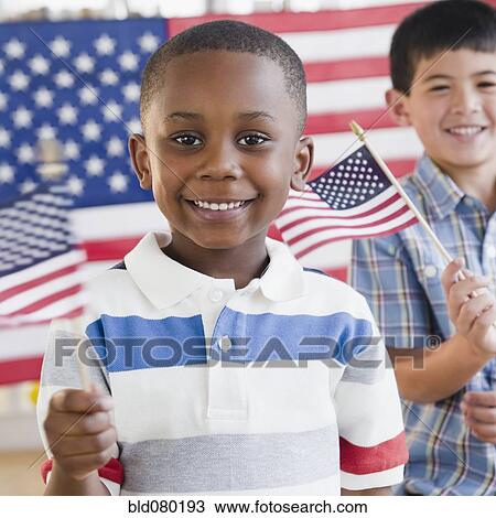 Stock Image - Boys holding small American flags. Fotosearch