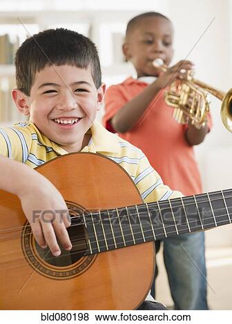 Stock Photo - Boys playing trumpet and guitar. Fotosearch