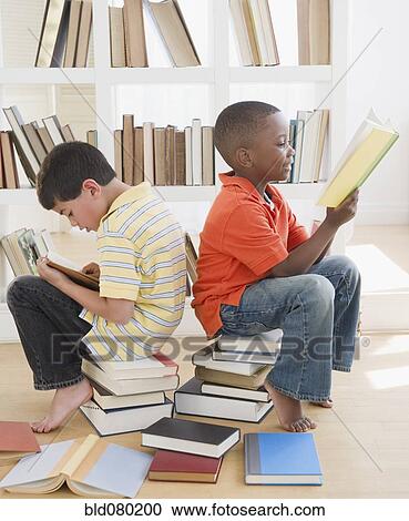 Boys sitting on stacks of books and reading View Large Photo Image Stock Image - Boys sitting on stacks of books and reading. Fotosearch