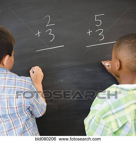 Stock Photograph - Boys solving math problems on blackboard. Fotosearch