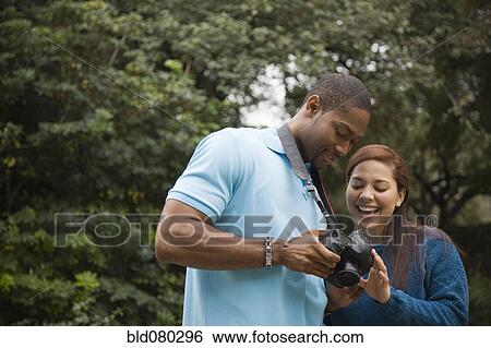 Couple looking at pictures on digital camera View Large Photo Image Stock Photograph - Couple looking at pictures on digital camera. Fotosearch