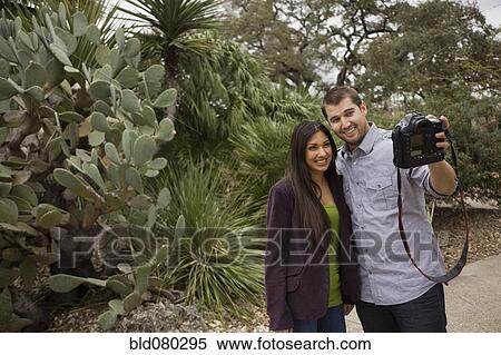 Stock Photography - Couple taking self-portrait with digital camera. Fotosearch