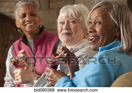 Stock Photo - Friends eating dessert in restaurant. Fotosearch