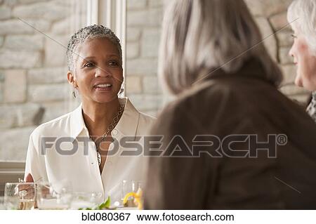 Stock Photo - Friends eating in restaurant. Fotosearch