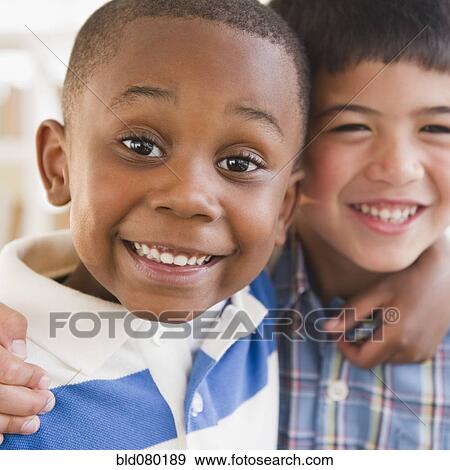 Stock Photo - Friends smiling and hugging each other. Fotosearch