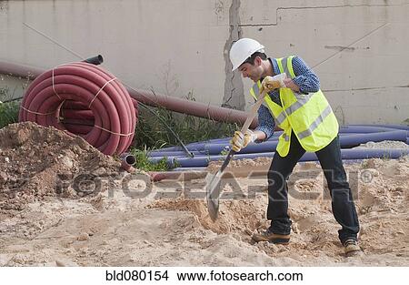 Picture - Hispanic construction worker digging. Fotosearch