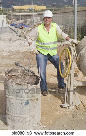 Stock Image - Hispanic construction worker standing on construction site. Fotosearch