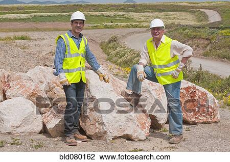 Hispanic construction workers standing near boulders View Large Photo Image Stock Image - Hispanic construction workers standing near boulders. Fotosearch