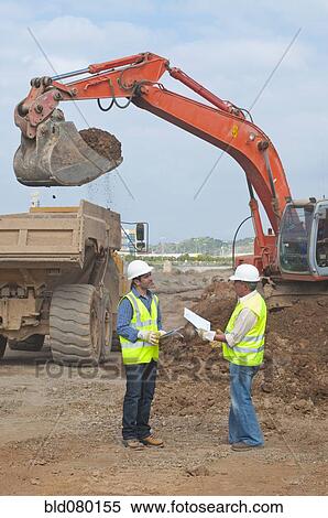 Stock Photography - Hispanic construction workers talking on construction site. Fotosearch