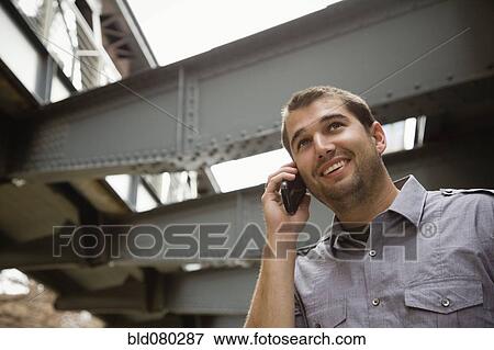 Hispanic man talking on cell phone View Large Photo Image Stock Photo - Hispanic man talking on cell phone. Fotosearch