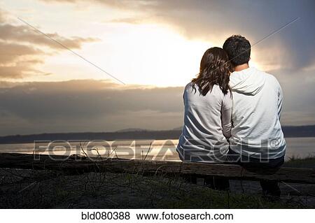 Stock Photo - Korean couple enjoying sunset at beach. Fotosearch
