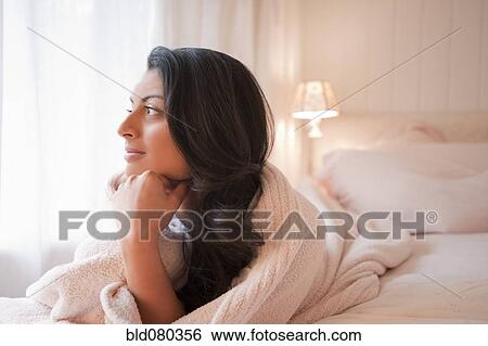 Middle Eastern woman laying on bed thinking View Large Photo Image Stock Photograph - Middle Eastern woman laying on bed thinking. Fotosearch