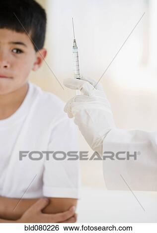 Mixed race boy worrying about injection View Large Photo Image Stock Photograph - Mixed race boy worrying about injection. Fotosearch